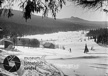 Hájovna a myslivna na Březníku, v pozadí vrchol Luzného, zdroj: http://fotobanka.seidel.cz/#!fotobanka/detail/203040601050050420001, foto: Josef Seidel, 1925